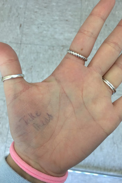 Michelle's hand with the note "Take Meds" on it