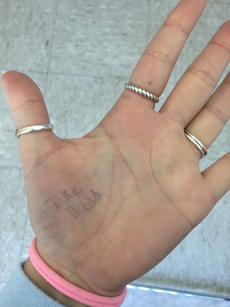 Michelle's hand with the note "Take Meds" on it