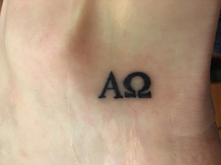 The alpha and omega tattoo on Michelle's right ankle